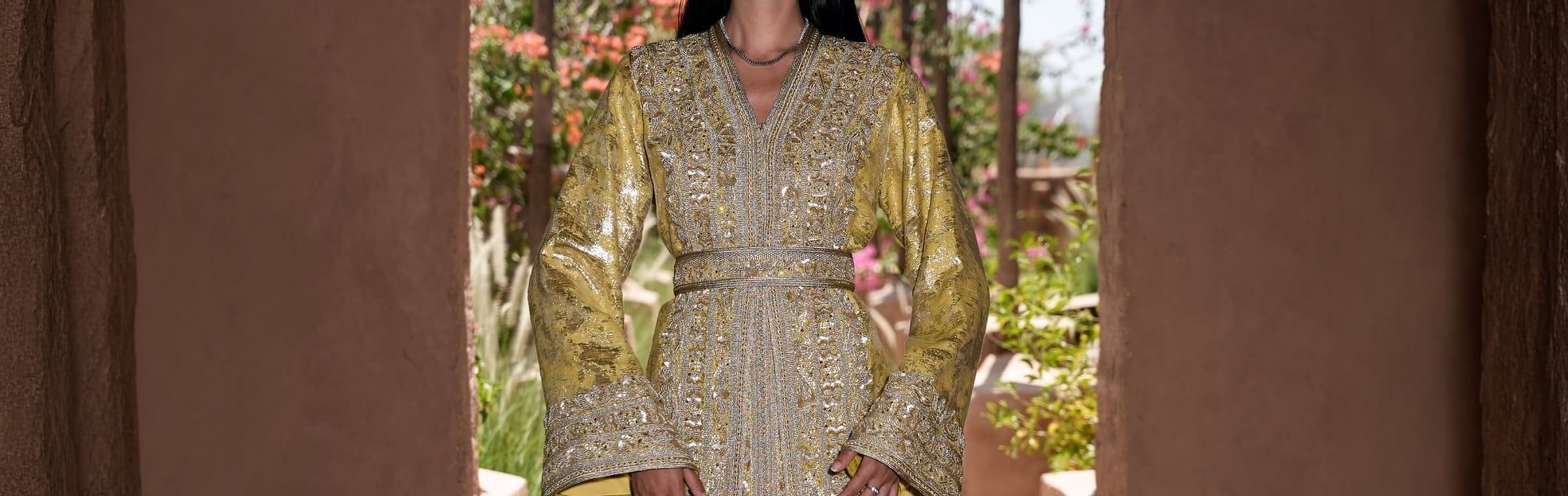 Citron brocade Moroccan kaftan with silver embroidery in a Marrakech garden