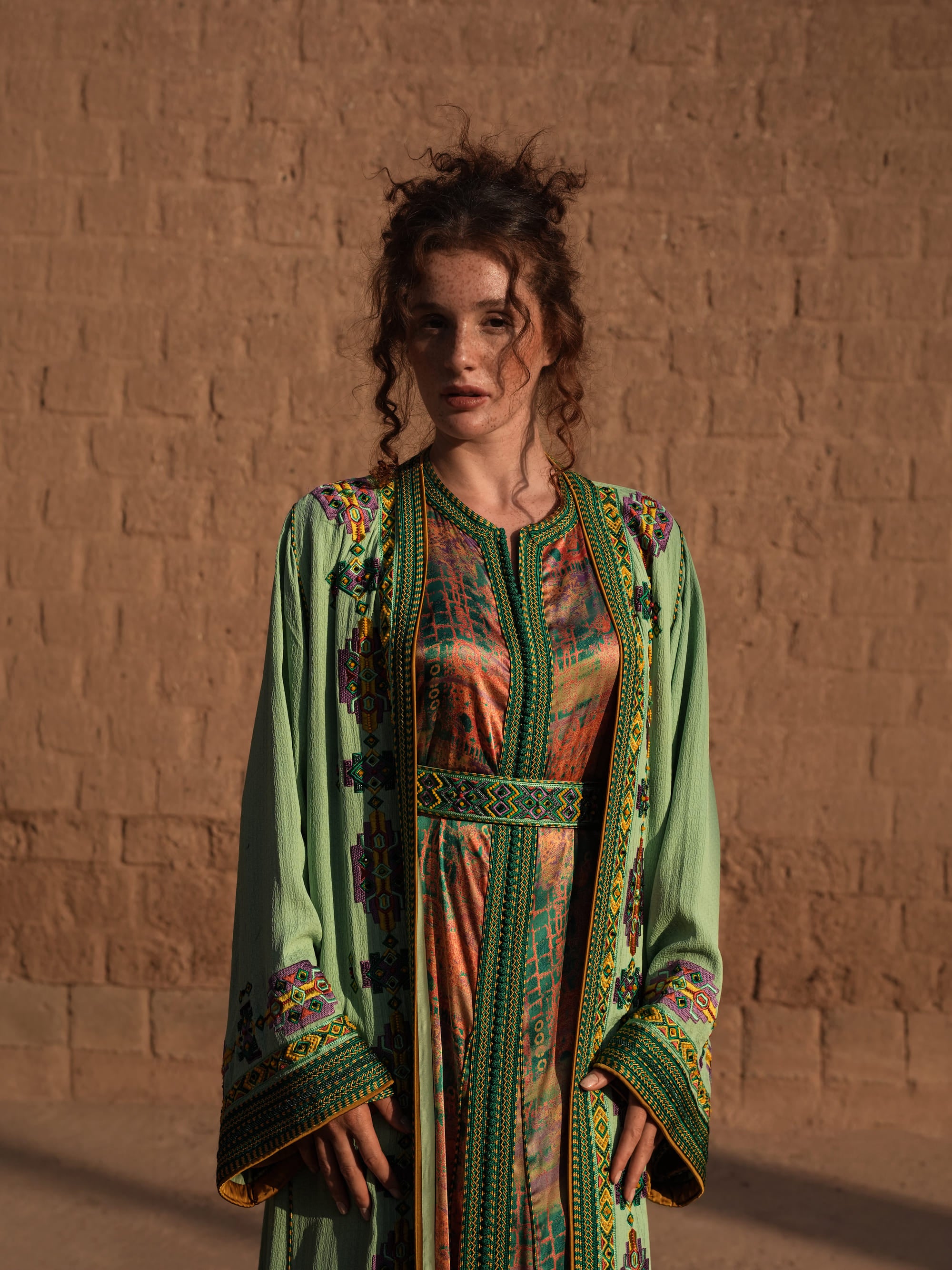 Anise Pavilion anise green Moroccan kaftan with Berber braid trims over a printed dress