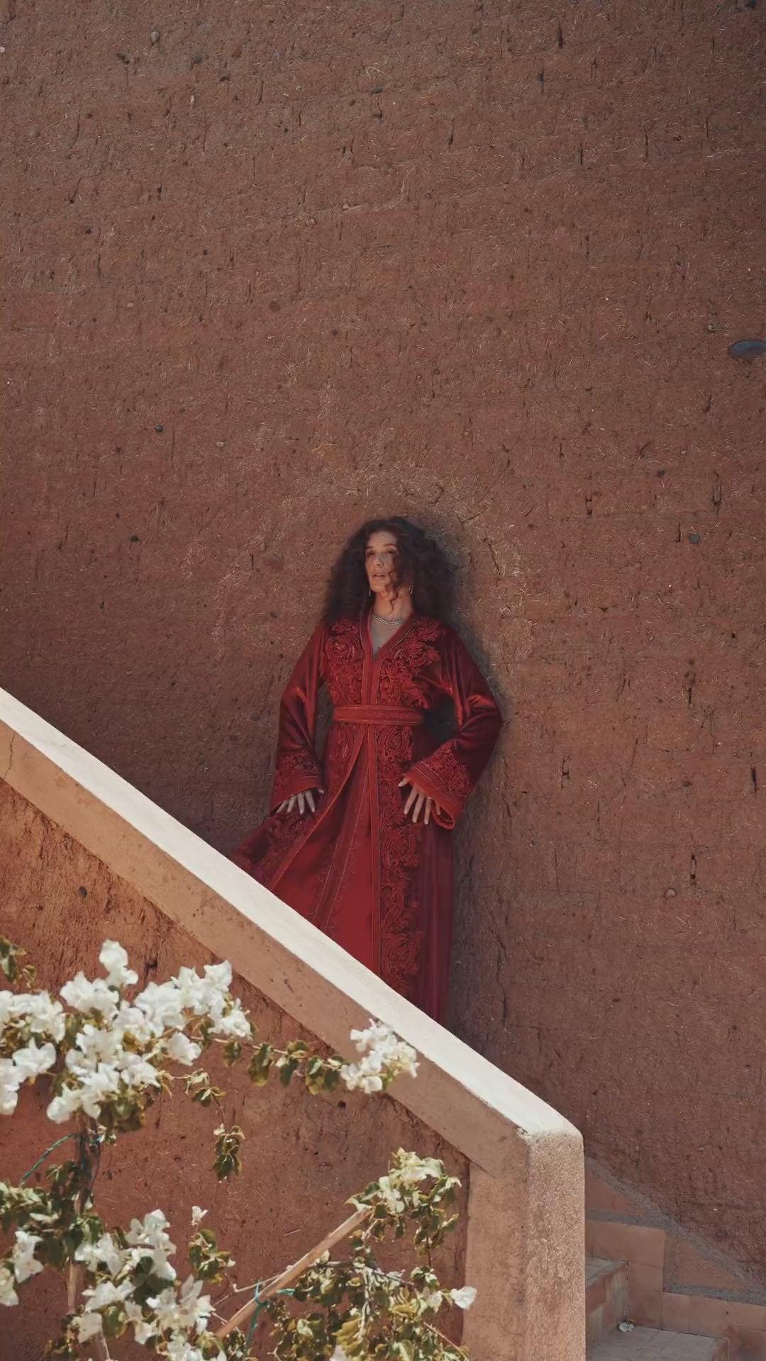 Garnet Adagio burgundy velvet Moroccan kaftan with tone-on-tone embroidery, matching belt and wide sleeves, in motion